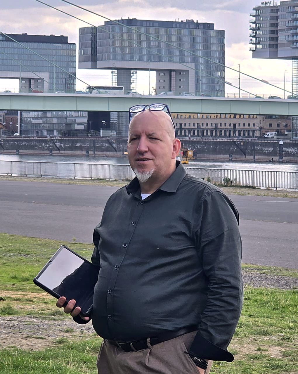 Andreas Gerhardt am Rheinufer in Köln vor den Kranhäusern, mit Tablet